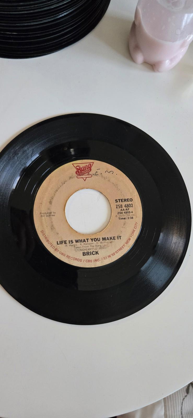 7-inch vinyl single by the band Brick Life Is What You Make It, Raise Your Hands